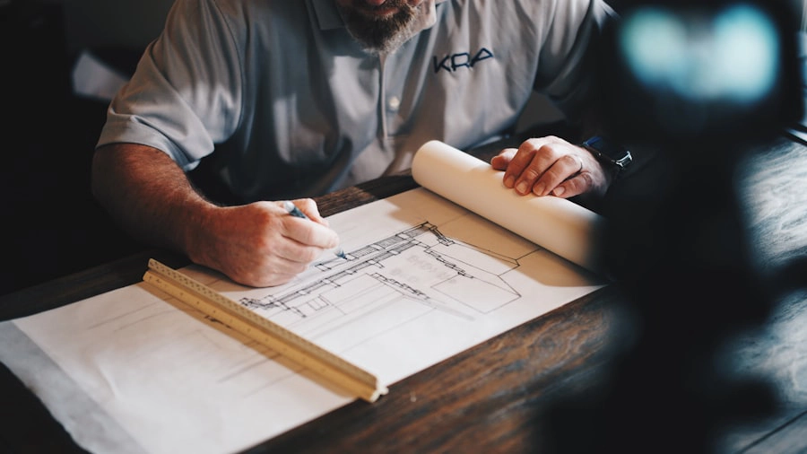 Architect drafting a commercial floor plan with pencil and ruler